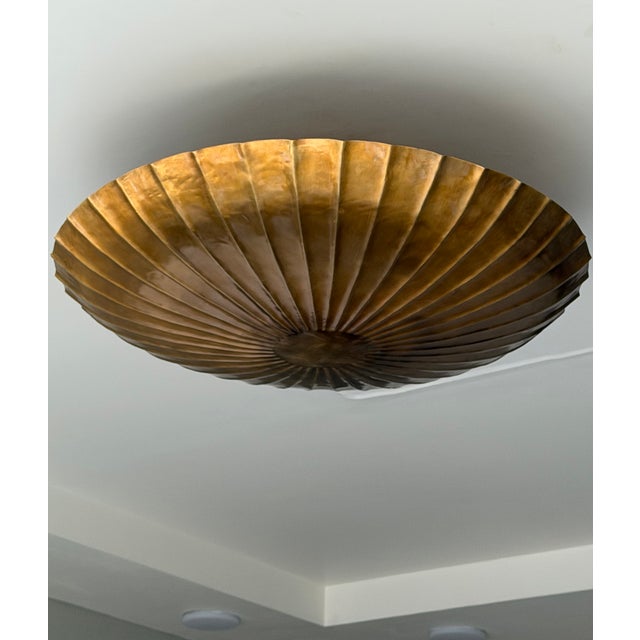 Bring sculptural elegance to your home with this handmade pure brass semi-flush ceiling light. Its scalloped, fluted shade...