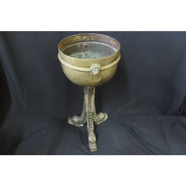 Heavy Brass Japanese planter with 3 ornate dolphines for legs. Lion head handles on either side of the bowl, bowl includes...