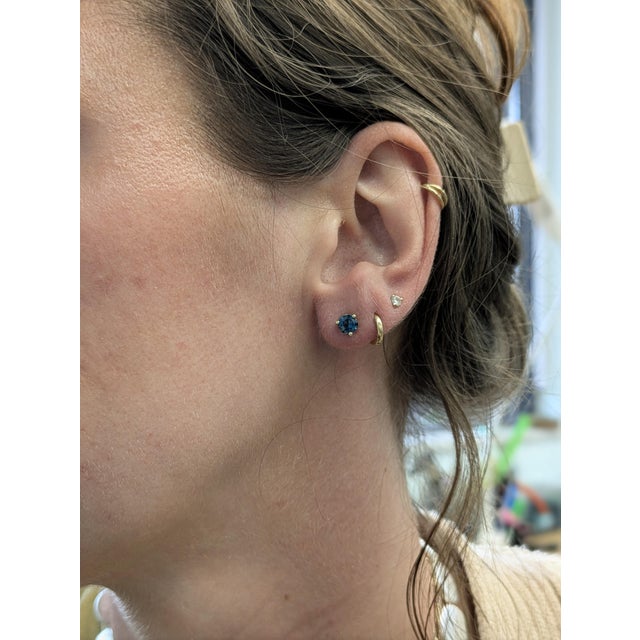 Grace your everyday with a touch of deep elegance—these martini-set London Blue Topaz studs in solid 14k yellow gold bring...