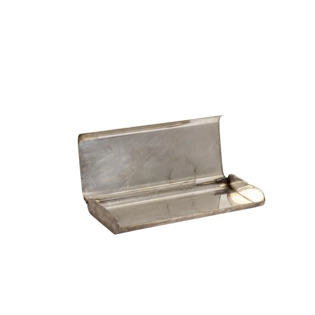 Rectangular pen holder in silvered metal. Ornate with gilt grooves on the top. Oxidated silver on outside parts. Work...