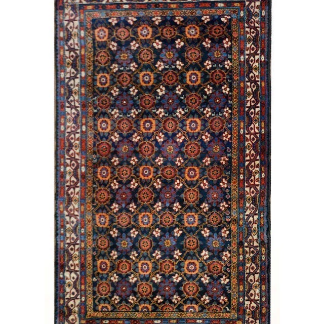A stunning early 20th century Persian Afshar rug with an all-over floral trellis pattern woven in brilliant reds, greens,...