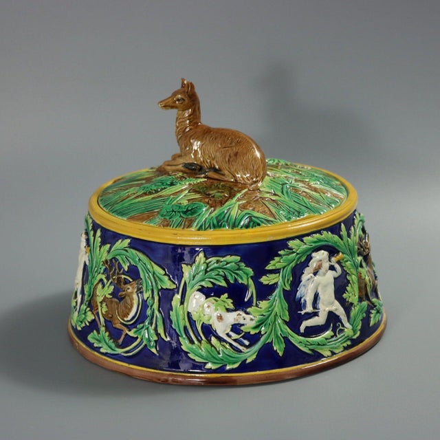 George Jones Majolica game pie dish with liner which features a recumbent deer (doe) forming the handle, on a leafy...