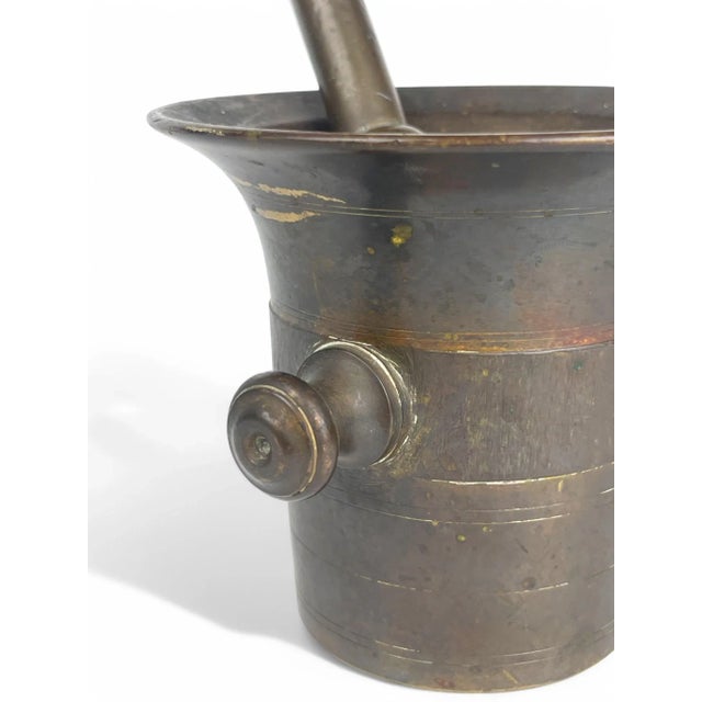 A 19th Century bronze mortar and pestle originating from England. In 19th century England, bronze mortars and pestles were...