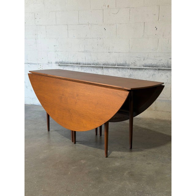 This versatile dining table features a space-saving drop-leaf design that expands into a large oval profile. The elegant...