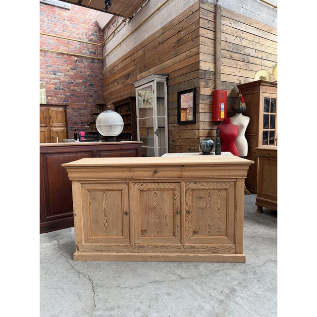 This antique fir sideboard has been fully restored. It features a functional drawer in the center and three lockable doors...
