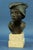 Bronze bust on a marble base depicting a Neapolitan street urchin wearing a classic fisherman's hat, cigarette, and...