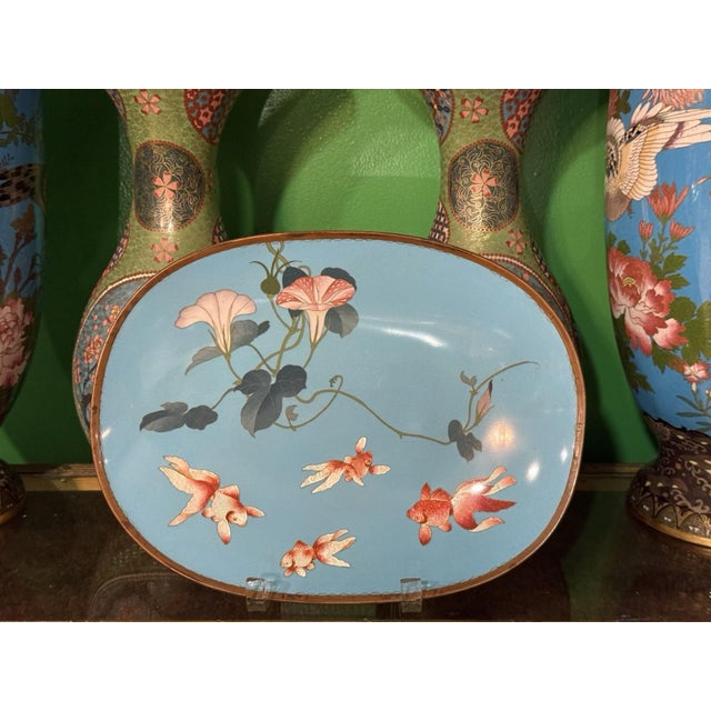 A refined Japanese cloisonné enamel tray of elegant oval form, measuring 12 inches wide by 9 inches high, signed on the...