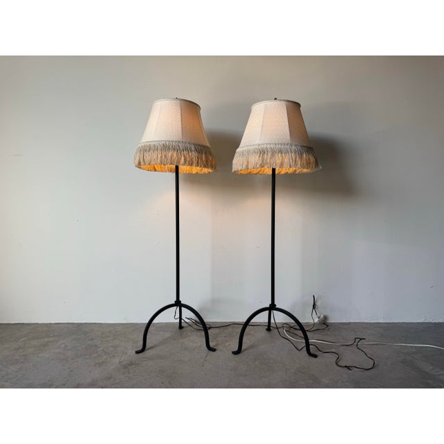 Striking pair of 1980s vintage metal tripod floor lamps featuring a clean, architectural silhouette. Each lamp is crafted...