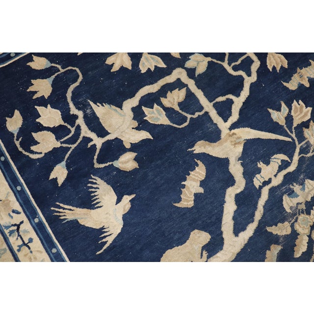 A late 19th century Chinese rug featuring 3 monkeys and some birds on a landscape scene. Navy field, beige accent colors....