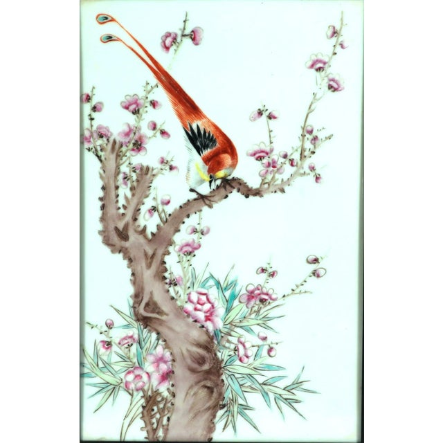 Chinese Famille Rose Plaque, Long-Tailed Bird on Flowering Peach Branch This Chinese porcelain plaque, twentieth century...