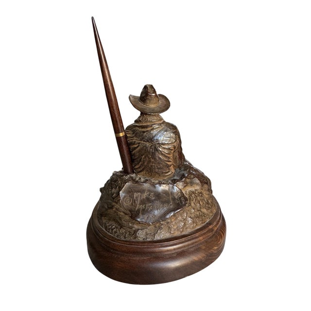 Signed and dated bronze desk sculpture by Western artist Mike McFarland, featuring a seated cowboy resting on a rocky...