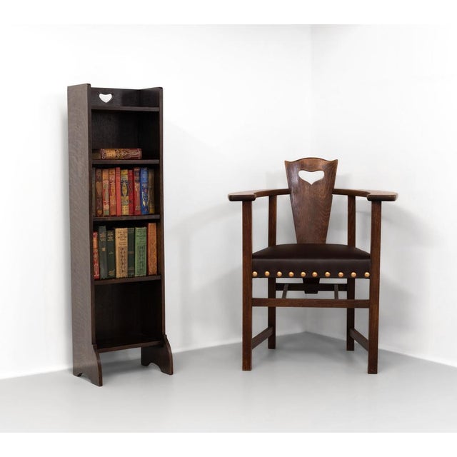 Liberty & Co narrow oak graduated open bookcase. Labelled. Circa 1905. Showing the squashed heart piercing classic to...