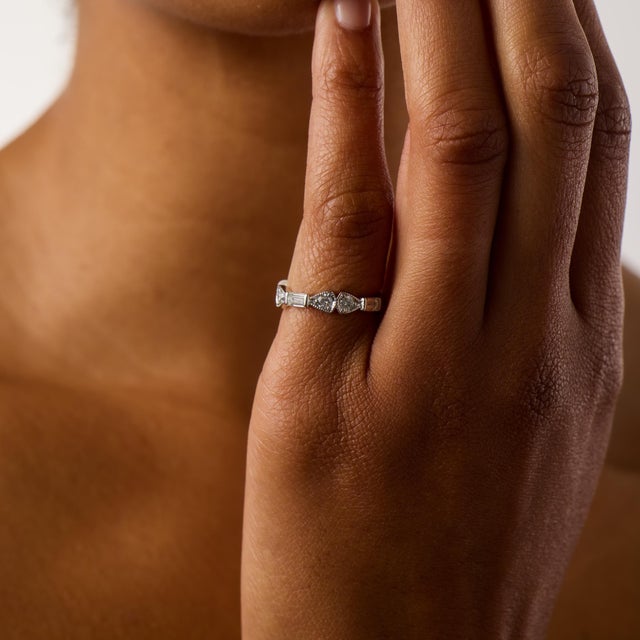 This elegant vintage eternity band showcases a refined combination of round brilliant and baguette cut diamonds totaling...