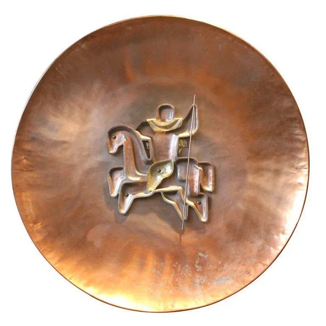 Riveted copper horseback rider on round copper disc.