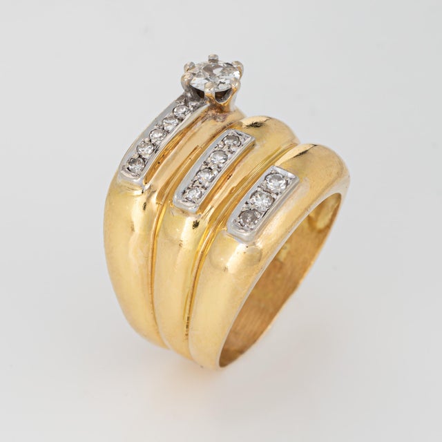 Stylish diamond wide band crafted in 18 karat yellow gold (circa 1970s). The larger old European cut diamond is estimated...