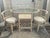 Charming vintage three-piece rattan bistro set featuring a sculptural glass-top table and two coordinating barrel-style...