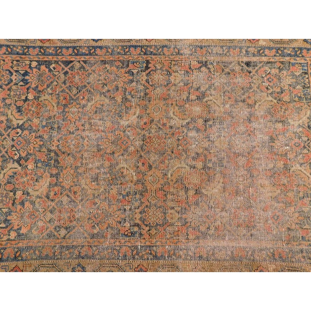 Antique Persian rug with evenly worn field in wool-on-wool foundation within camel border. Circa 1920.