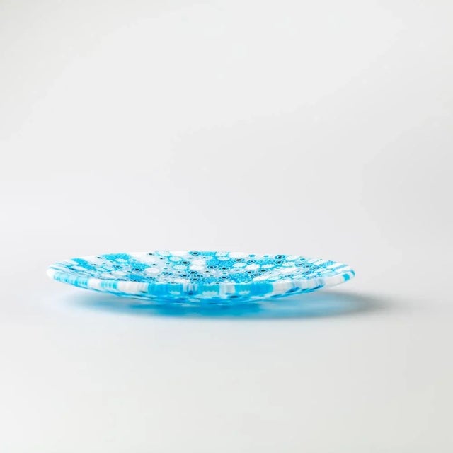 Murano glass plate made by melting together sections of glass rods in a furnace, with each section depicting a small...