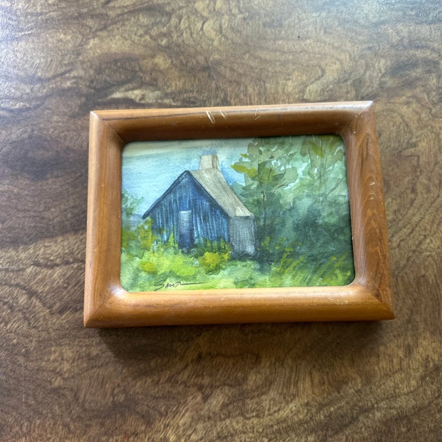 This charming little painting evokes the nostalgia of quiet retreats and simpler times. “Cabin in the Green” shows a...