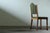 A set of four slim oak dining chairs from the mid-20th century. These chairs have a light and elegant presence, with...