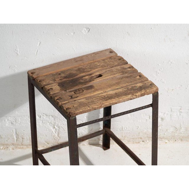 This antique industrial stool in pine wood and iron is an industrial seat with a tubular iron frame and a pine slatted...