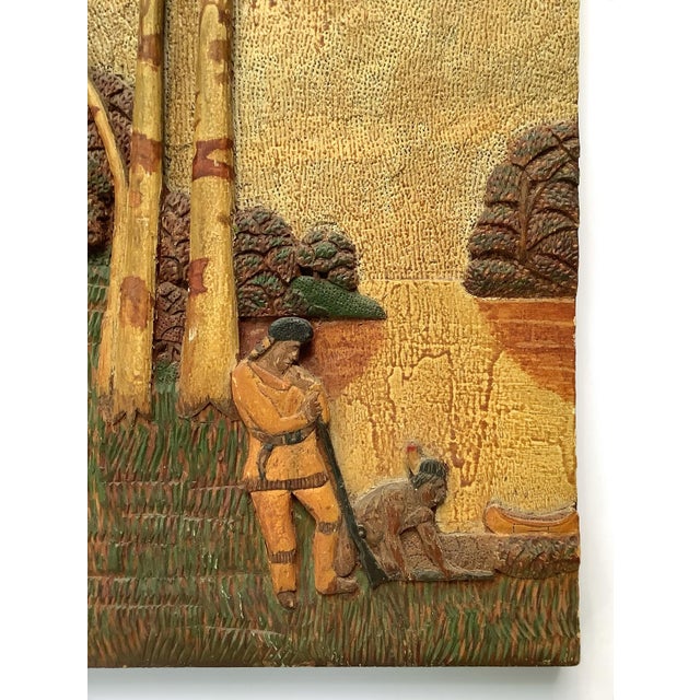 Circa early 1900s hand carved wood plaque with trapper, Native American guide and canoe. Entire board is carved and hand...