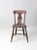This is an antique wooden dining chair. The rustic plank seat chair features a decorative "fiddle" back. Aged, mauve paint...