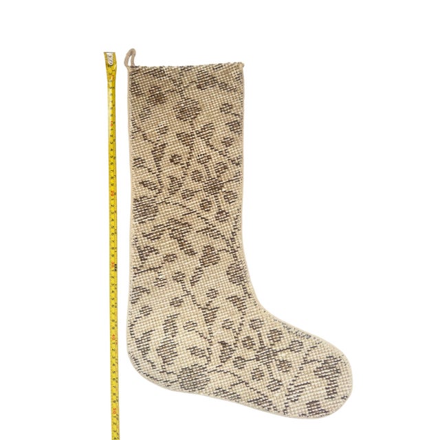 This vintage wool kilim stocking features a subtle, scattered diamond motif in deep chocolate brown against a soft cream...