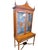 Elegant two-piece display cabinet featuring decorative glass-front doors, painted urn medallions, scrolling floral...