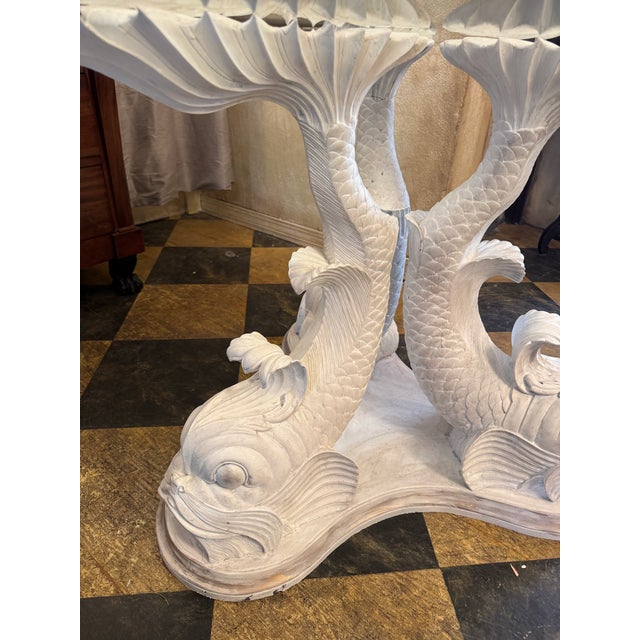 Vintage painted round carved wood dolphin/ koi pedestal table. Distressed white finish with muted gold accents on the base...