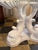 Vintage painted round carved wood dolphin/ koi pedestal table. Distressed white finish with muted gold accents on the base...