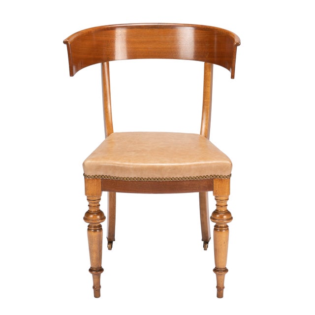 An Austrian Biedermeier klismos side chair from around 1830, its curved beechwood frame finished in a warm honey-brown...