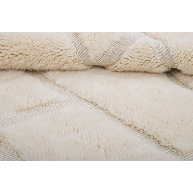 Textured hand-knotted wool rug in Ivory, featuring an organic grid of raised linear segments. Its sculptural pattern and...