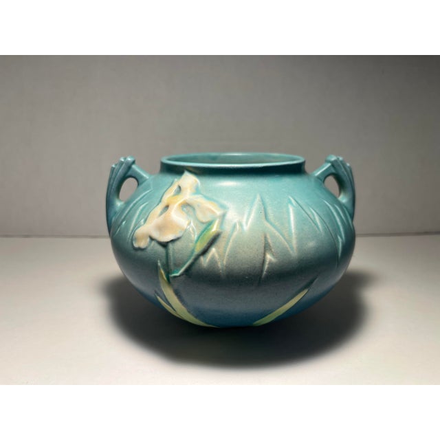 Offered for sale is a beautiful original Roseville Pottery Iris Blue vase, shape 357-4, introduced in 1939. This charming...