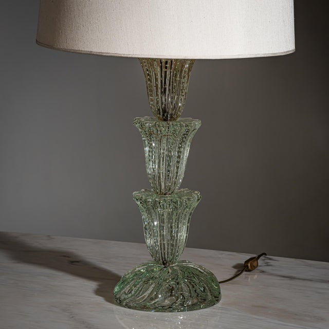 Table lamp in clear glass with enclosed air bubbles. The composition is formed by three-tiered, flower-shaped elements...