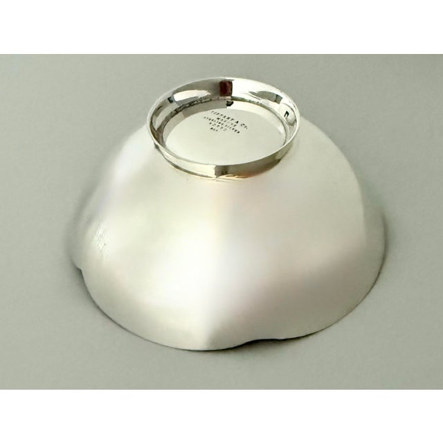 A Tiffany & Co. 925 sterling silver candy or nut bowl in a modern, simple design with a scalloped edge. Engraved at the...