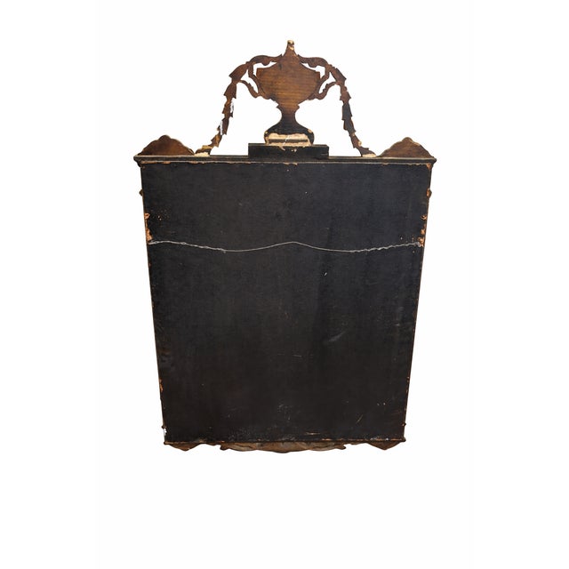 A striking antique wood mirror dating to the turn of the 20th century, featuring an ebonized wood frame accented with...