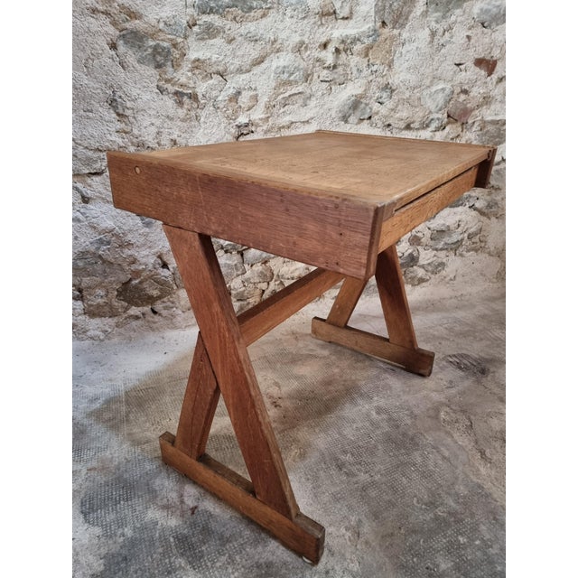 Vintage French school desk dating from the 1960s, made of oak. The desk has a simple trestle-style base and a hinged...