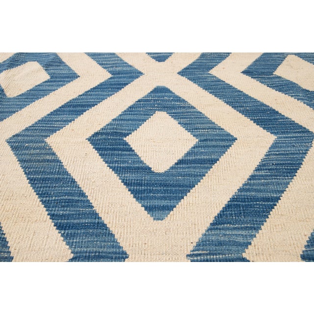 A mid-20th-century Persian Kilim rug, handwoven circa 1956. This elegant flat-weave rug exemplifies the minimalist...