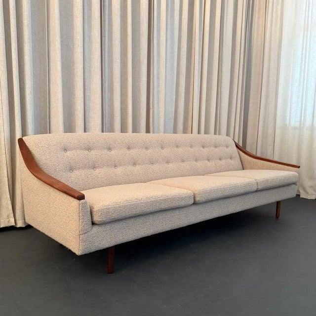 This refined Scandinavian Modern sofa marries comfort and style for the best of both worlds. It features a scoop teak trim...