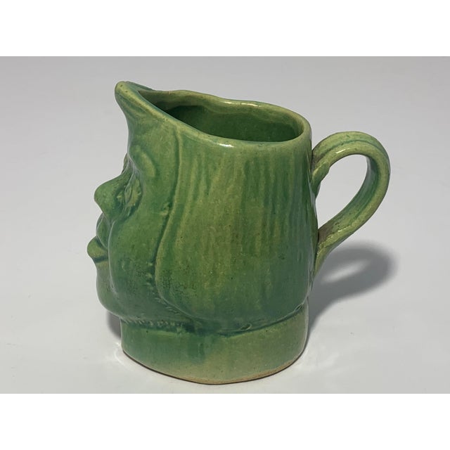 Antique Glazed Stoneware Face Creamer for your consideration. The creamer measures approx. 3 1/4 inches tall and approx. 3...