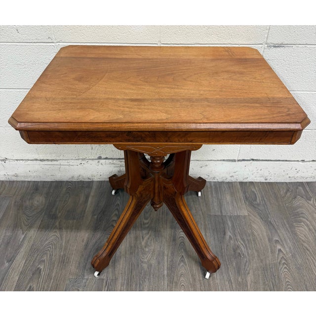 This is a stunning antique Victorian Eastlake walnut parlor table featuring a richly figured walnut top, burl walnut...