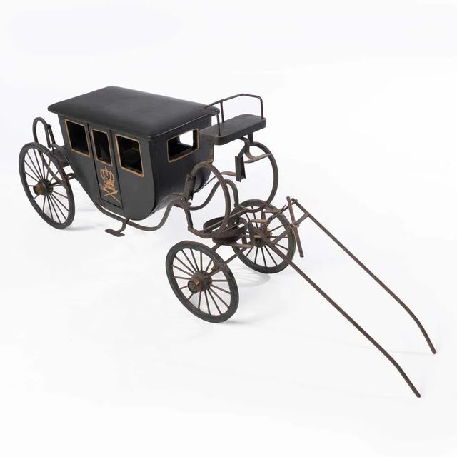 Model of a Royal Coach, detailing a carved wood and gilt decorated coach with on working door. Resting on a metal...