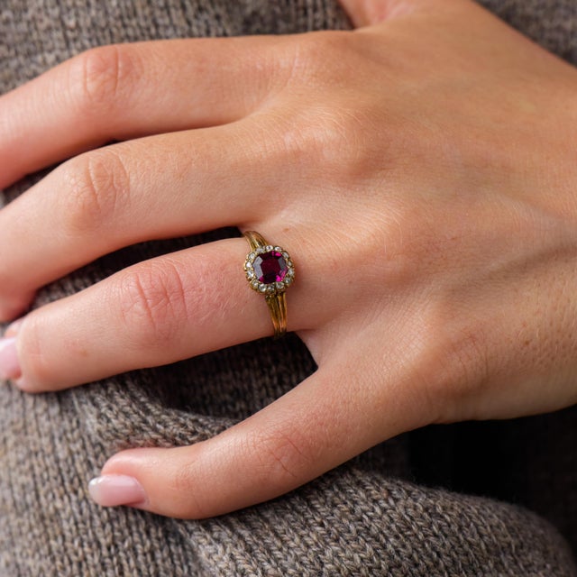 This charming Victorian cluster ring is a beautifully distinctive jewel from the 1900’s, centered by an Asscher cut pink...