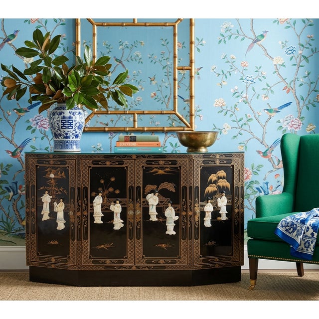A striking vintage Chinoiserie sideboard crafted in black lacquered wood and richly decorated with raised mother-of-pearl...