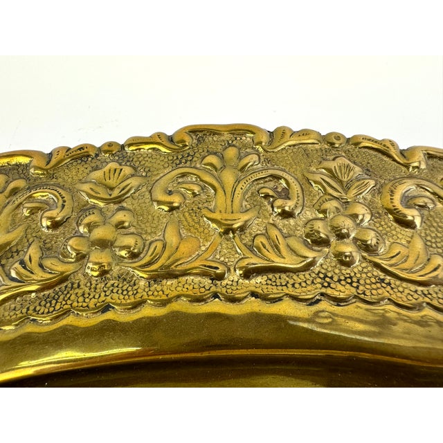 This beautiful brass tray features a meticulously detailed floral and scrollwork motif, highlighting expert craftsmanship...