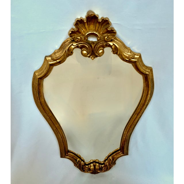 Imported from Belgium. Ornate rococo style gilded mirror. Classic gold finish adapts to any decor. The diminutive size...