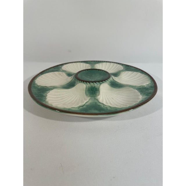 A beautiful classic French Longchamp glazed majolica oyster plate with a vibrant green basket weave background and brown...