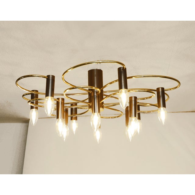 Designer ceiling lamp Designer ceiling lamp made around 1970. Twelve lights. Curved brass tubes, burnished sockets. The...