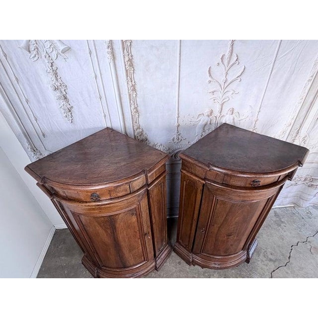 Impressive pair of Italian corner cabinets, circa late 18th century. Each cabinet features a serpentine bowed front with...
